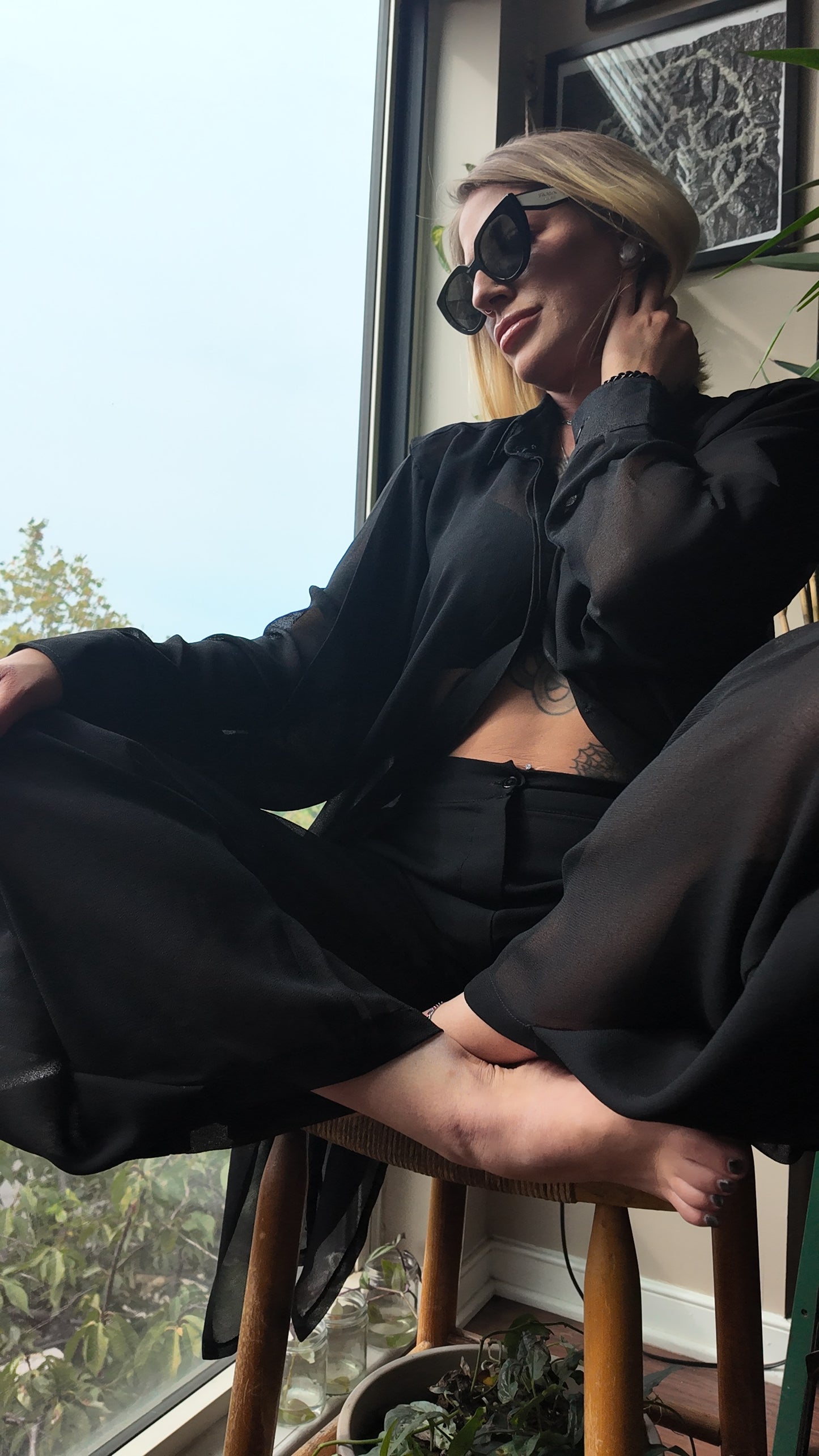 A woman seated gracefully in a Matching Set- Kaftan Top, presenting a stylish black matching kaftan set African outfit. The outfit, which is a trendy african two piece set, includes a sheer kaftan and laid-back pants, perfect for showcasing contemporary african women attire. The look embodies traditional african suit aesthetics while celebrating the vibrant spirit of west african fashion, ideal for anyone who loves african kaftan dresses for ladies.