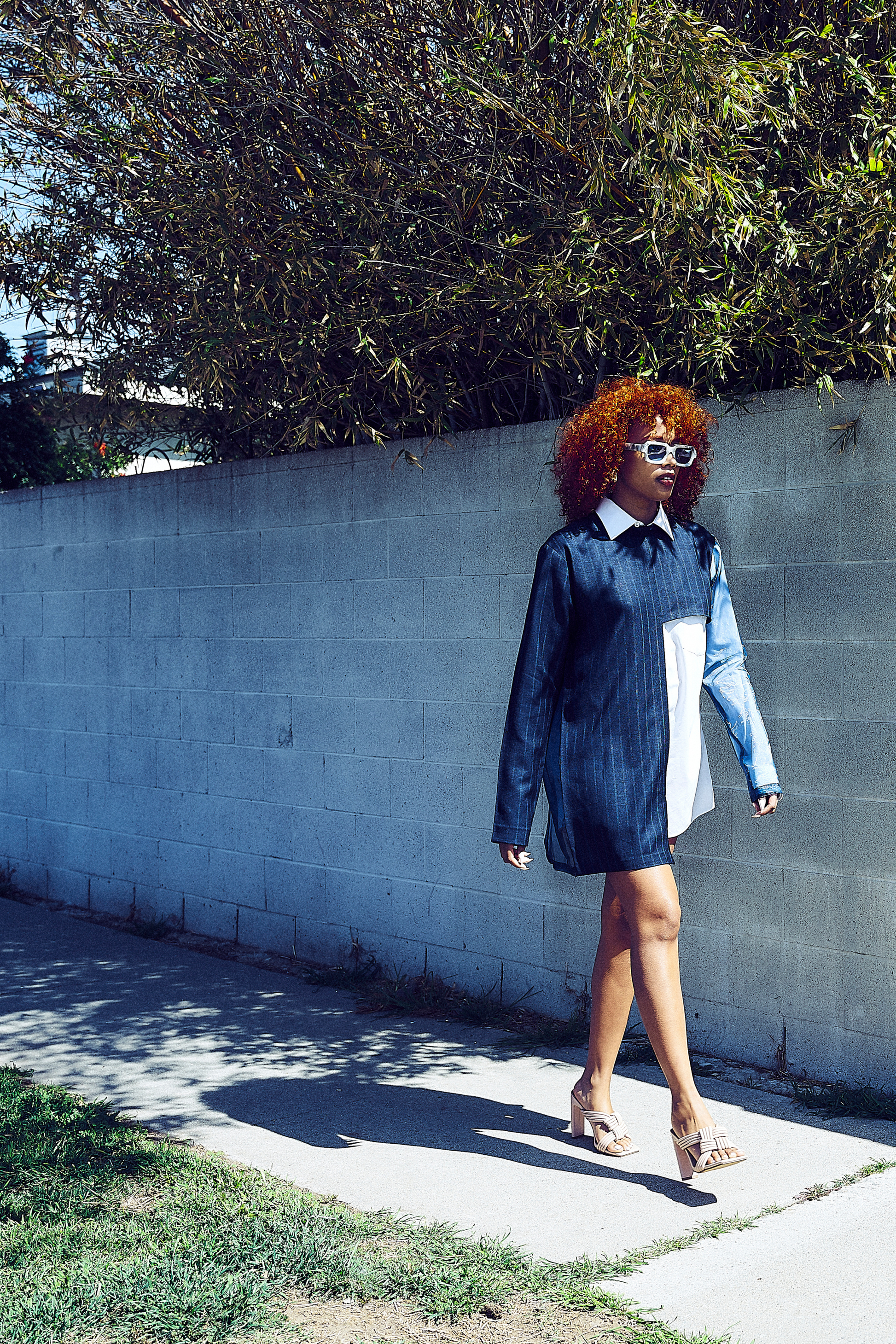 A model walks casually in a Modern Abstract Shirt, highlighting its architectural look. This outfit aligns with elegant African dresses for ladies, portraying a unique blend of sophisticated and relaxed African dress styles for women.