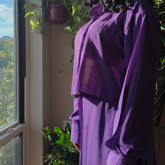 Another view of the Versatile Translucent Blouse in purple, beautifully showcasing its sheer design in a sunlit setting. This blouse is a trendy option within women's African clothing, appealing to those who love unique African apparel from esteemed African clothing brands.