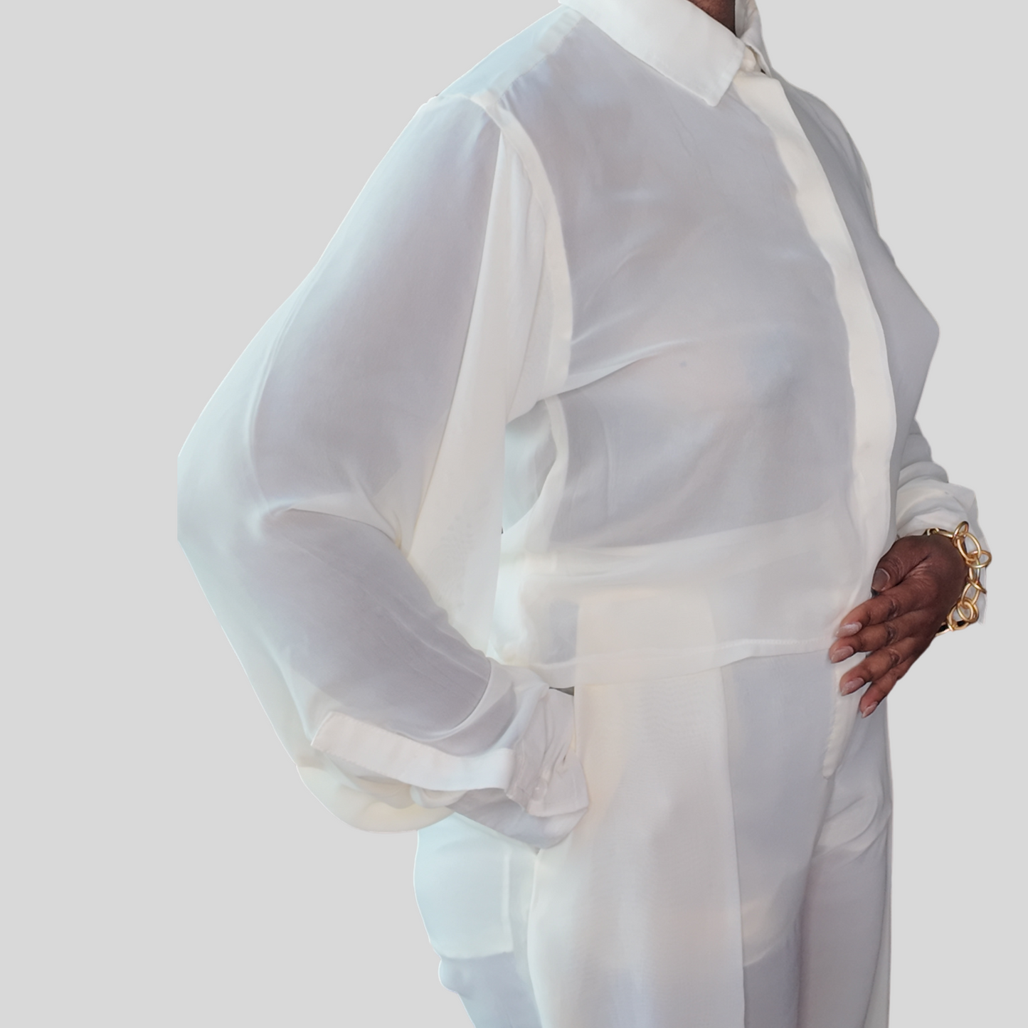 A model highlighting the Versatile Translucent Blouse in white, styled effortlessly for a sophisticated look. This piece is a fantastic representation of women's African clothing, perfect for anyone in search of fashionable African apparel from notable African clothing brands.