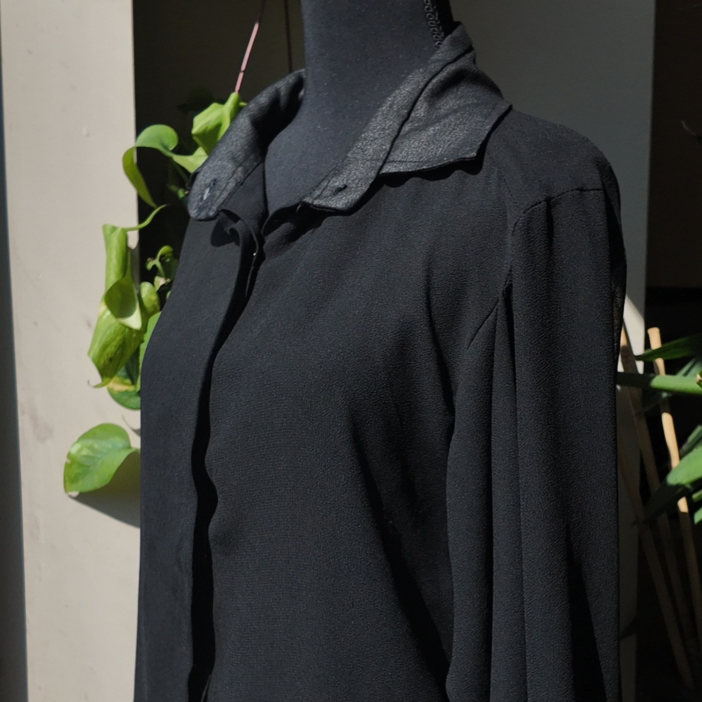 A mannequin displaying the Versatile Translucent Blouse in black, featuring a chic collared design. This blouse reflects the essence of women's African clothing, making it a standout choice for fans of stylish African apparel from recognized African clothing brands.